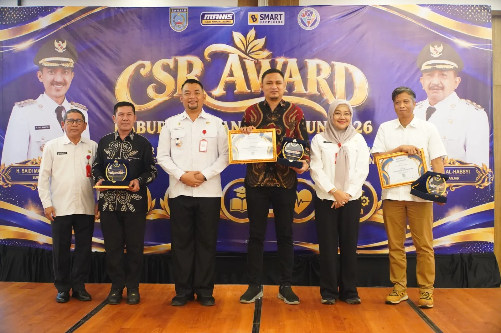 Penyerahan penghargaan oleh Sekretaris Daerah Kabupaten Banjar, H. Yudi Andrea, S.STP., M.H., kepada tim United Tractors dan Kadya Caraka Mulia.